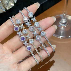 Detailed shot of multiple colors of French-style zircon flower bracelets on hand.