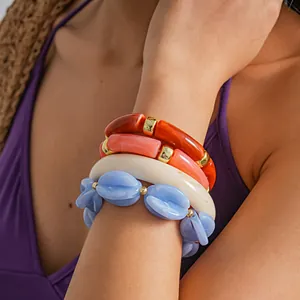 Close-up of layered marbled acrylic elastic bracelets on wrist in vibrant colors