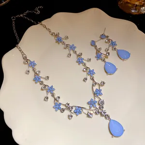Macro view of light blue floral resin jewelry set with sparkling crystal accents