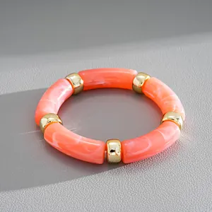 Detailed view of an orange marbled acrylic stretch bracelet with gold-tone spacers