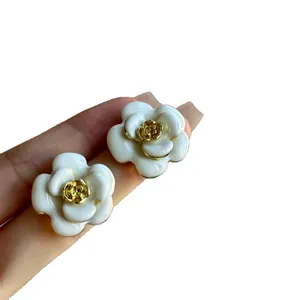 Elegant French milky white camellia flower earrings with a vintage gold rose center piece.