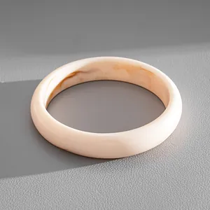 Macro view of minimalist cream acrylic bracelet featuring elegant marble ink-dye textures