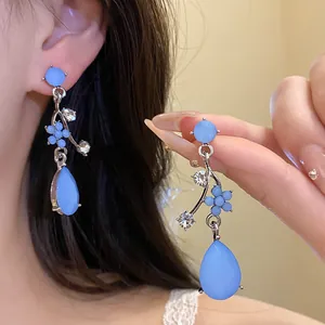 Elegant blue flower water-drop earrings with rhinestones shown worn on ear for detail