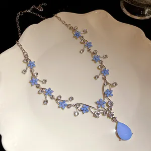 Detailed shot of blue resin flower necklace with a large teardrop pendant on a plate