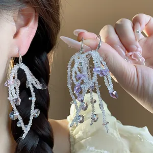 Detail view of elegant glass bead tassel earrings featuring purple and clear crystals