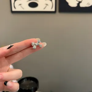 Detailed macro view of a minimalist silver zircon bow ear clip for non-pierced ears
