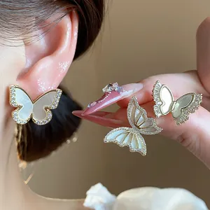 Detail showing 14k gold plated butterfly earrings with zircons and shell inlay.