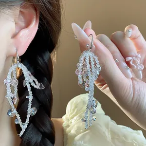 Detailed macro view of elegant sparkling glass beaded tassel earrings on an Asian model
