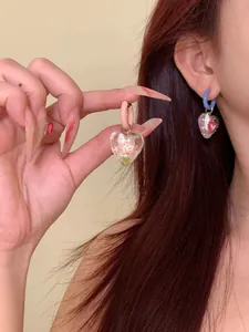 Close-up of asymmetric colorful heart drop earrings with pink and blue hoops