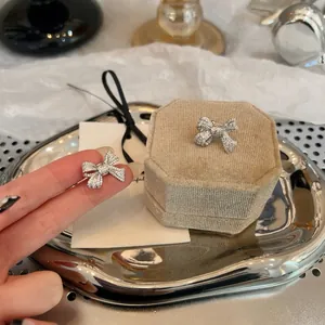 Detail view of sparkly silver zircon pavé bow clip-on earrings for non-pierced ears