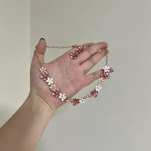 Detailansicht des eleganten Schmucksets mit rosa und weißen Emaille-Blumen-Motiven