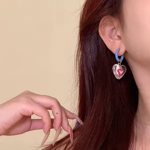 Macro detail of dopamine-style asymmetric heart drop earring worn by an Asian model