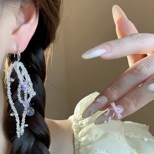 Close-up detail of elegant glass bead tassel earrings featuring purple crystal accents