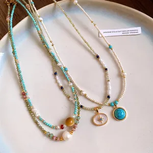 Detail view of several vintage-style beaded necklaces featuring turquoise and pearl accents