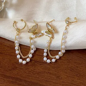 Close-up of elegant 14k gold plated butterfly earrings with pearls and delicate chains detail