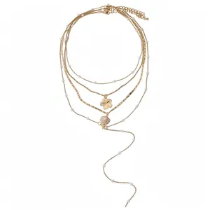 Elegant gold multi-layered necklace set with white pearls, shell and flower charms