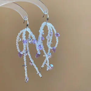 Macro view of exquisite purple and white glass beaded tassel hook earrings for women