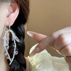 Exquisite detail shot of elegant glass beaded bow tassel hook earrings on a model