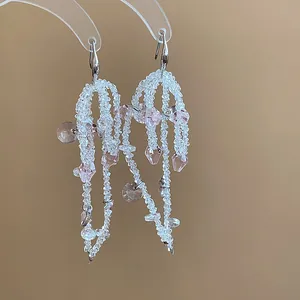 Close-up of elegant handmade glass beaded bow tassel earrings with pink crystal accents