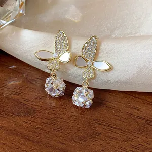 Close-up of elegant butterfly drop earrings with cubic zirconia and shell petals.