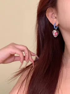 Detailed close-up showing a vibrant dopamine-style transparent heart earring on a model ear