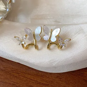 Macro view showing 14k gold plated butterfly earrings with zircon and shell wings