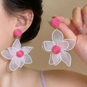 Oversized bohemian style raffia flower drop earrings featuring white mesh lace petals