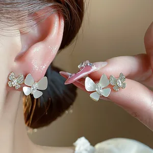 Detailed close-up view of 14k gold plated butterfly stud earrings with zircon stones.