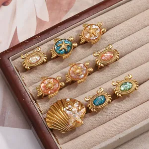 Vue détaillée de bagues thème océan avec tortue crabe et coquillage en or 18 carats