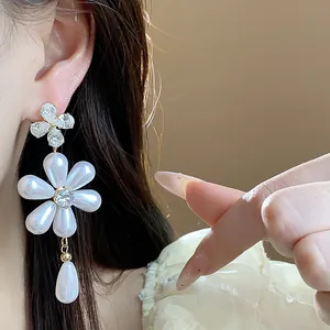 Detailed close-up showing floral zircon and pearl drop earrings on an Asian model