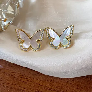 Close-up of 14k gold plated butterfly stud earrings with iridescent shell inlay