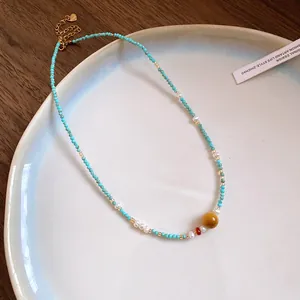 Detailed view of a vintage beaded necklace featuring turquoise stones and freshwater pearls.