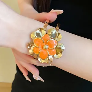 Vintage style gold metal open bangle bracelet featuring orange enamel double-layer flowers