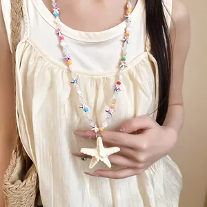 Dettaglio di una collana colorata con stella marina e perline per stile vacanza