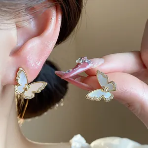 Detailed macro view of elegant 14k gold plated butterfly earrings featuring zircon accents.