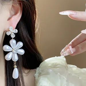 Close-up of elegant floral pearl drop earrings with sparkling zircon accents.