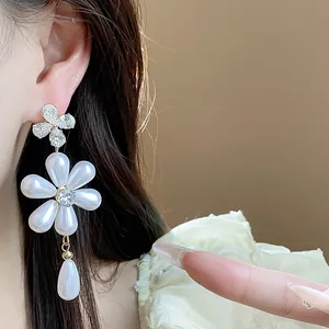 Detailed macro view of elegant silver zircon flower earrings with white pearl drops