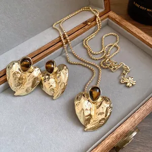 Detailansicht von goldenem Herz-Schmuckset mit Tigerauge-Steinen in einer Box