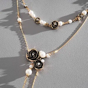 Vue détaillée d'un collier de perles vintage avec roses en émail noir et strass