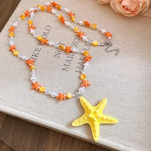 Primo piano di collana colorata con stelle marine, perle e ciondolo a stella gialla