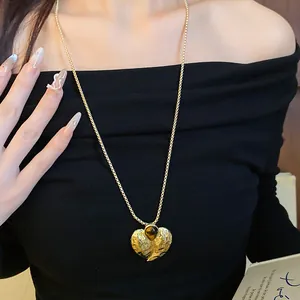 Detailansicht der goldenen Herz-Halskette mit Tigerauge-Stein im eleganten Falten-Design