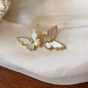Detailed view of 14k gold plated butterfly stud earrings with shell inlay and shiny zircons.