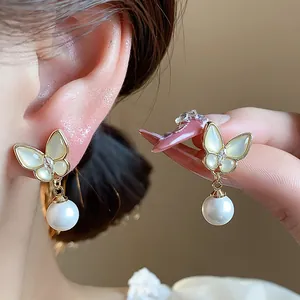 Close-up of elegant 14k gold plated butterfly pearl earrings with zircon detail