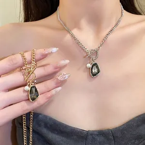 Elegant vintage court style necklace with irregular dark gem pendant and pearl accent.