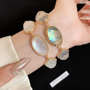Detail view of vintage French resin bracelet with faceted oval stones and gold chain.