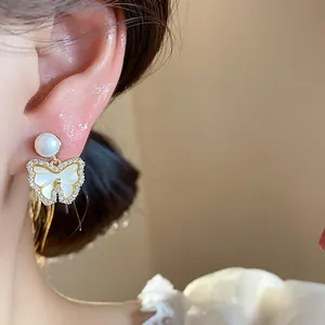 Close-up view of an elegant 14k gold plated butterfly stud earring featuring pearl and zircons