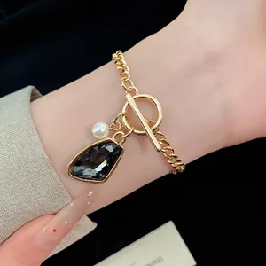 Elegant gold chain necklace with irregular dark crystal and pearl charm in vintage style
