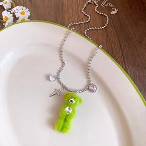 Detail of cute green plush bear necklace with crystal heart and star charms