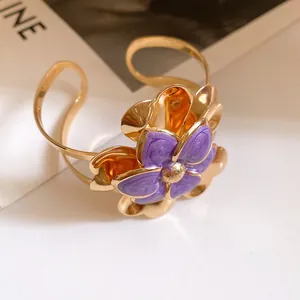 Detail view of purple enamel flower on gold retro cuff bracelet