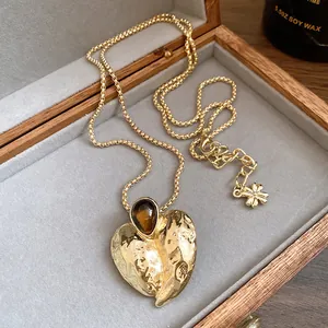 Detailansicht des Herzanhängers mit Tigerauge-Stein an einer eleganten goldfarbenen Kette.